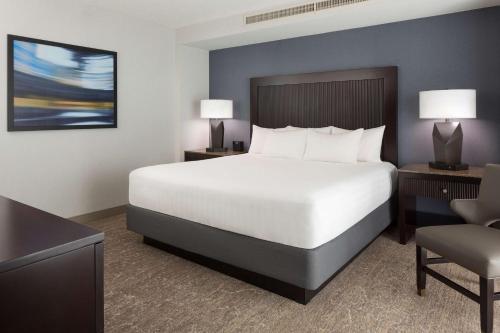 a bedroom with a large white bed and a chair at Hyatt Regency San Francisco Airport in Burlingame