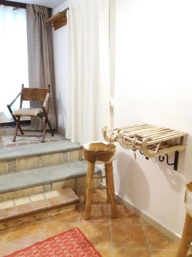 a room with a bed and a chair and a stool at La Casetta Del Dahu in Limone Piemonte