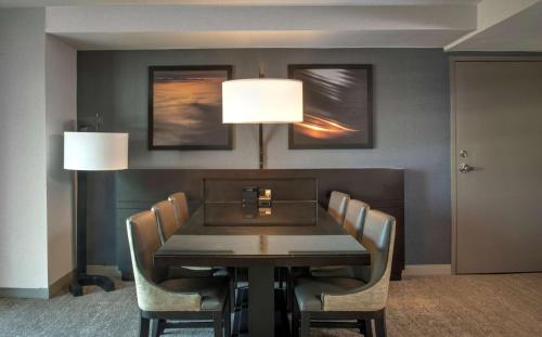 a dining room table with chairs and a lamp at Hyatt Regency San Francisco Airport in Burlingame