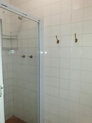 a shower with a glass door in a bathroom at Zebra Crossing Backpacker in Cape Town