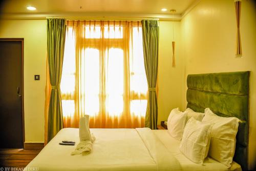 a bedroom with a large bed with a window at Golden Kuensel Resort & Spa in Kalimpong