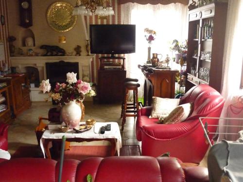 a living room with red chairs and a tv at Domaine De Rode Buze in Cahors