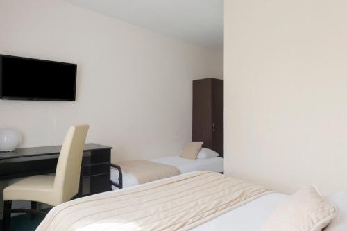 Una cama o camas en una habitación de The Originals City, Hôtel Paris Sud, Orly-Draveil