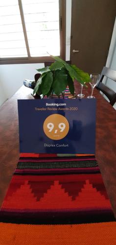 a sign on a table with a plant on it at Dúplex Confort in Posadas