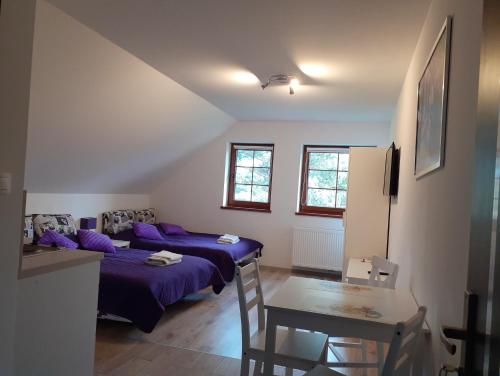 a room with two beds and a table in it at Agroturystyka Aura in Kostrzyca