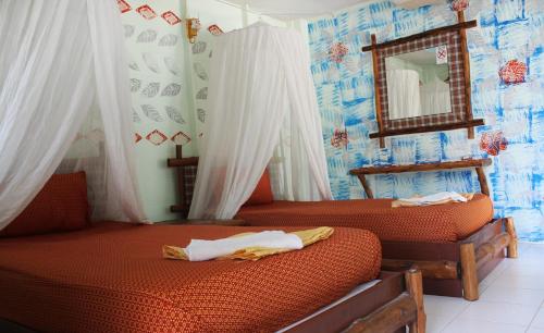 een slaapkamer met 2 bedden, gordijnen en een spiegel bij Chill Out Bar and Bungalows in Tonsai Beach