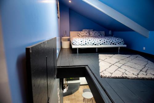 - une chambre avec un lit et un mur bleu dans l'établissement Le cottage du clos des Forges, à Saint-Leu-dʼEsserent