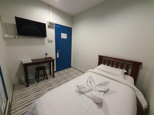a bedroom with a bed with a flower on it at De Chukai Hotel in Kampong Kemaman