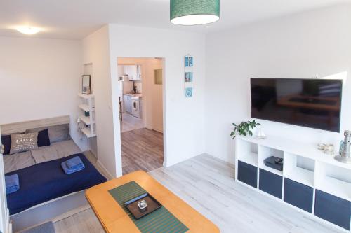 salon z kanapą i telewizorem w obiekcie Cosy Apartment in Sopot w mieście Sopot