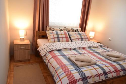 a bedroom with a bed with a window and two lamps at Apartman Borsalino Subotica in Subotica