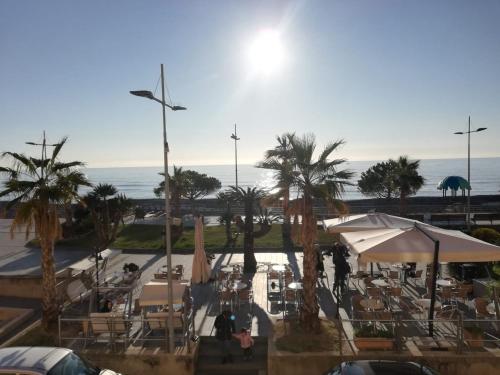 einen Blick auf eine Terrasse mit Palmen und das Meer in der Unterkunft B&B 47 in Loano