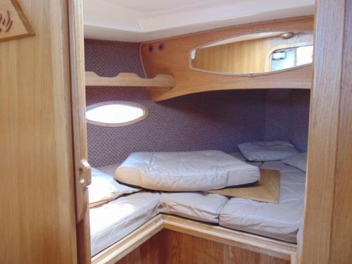 a small room with two bunk beds in it at Jacht motorowy Calipso 750 in Ryn