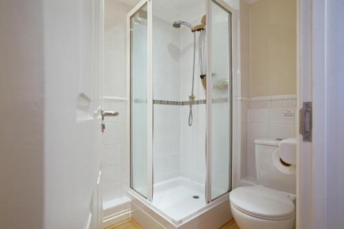 a bathroom with a shower and a toilet at Compass Point in Carbis Bay