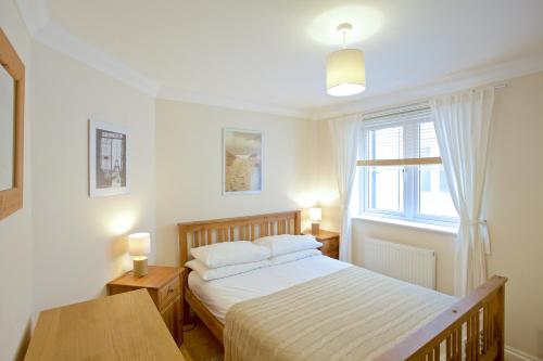 a bedroom with a bed and a window at Compass Point in Carbis Bay