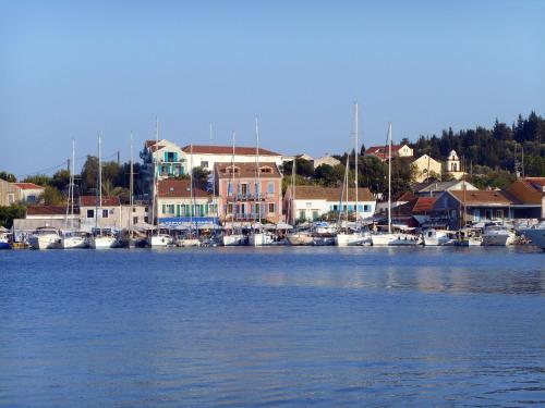 a group of boats docked in a marina with houses at Polytropon Studio ground floor in Kefallonia
