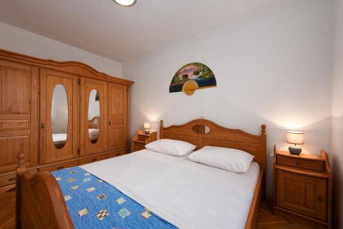 una camera con un letto, mobili in legno e 2 lampade di Apartment Europe with Sea View a Ičići