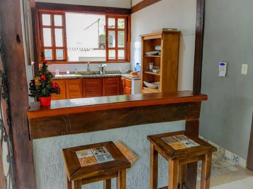 una cocina con encimera y 2 mesas. en Casa com piscina, bem localizada, en Bonito