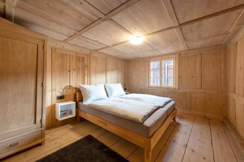 1 dormitorio con 1 cama en una habitación de madera en Ferienwohnung Gertrud, en Bezau