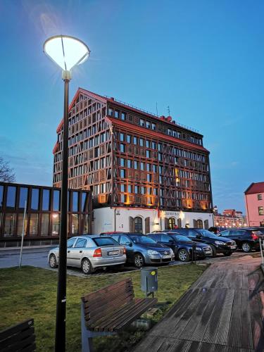 duży budynek z samochodami zaparkowanymi na parkingu w obiekcie Old Town Loft w Kłajpedzie
