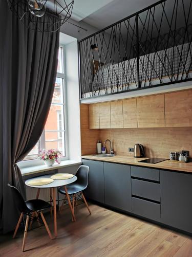 una cucina con tavolo, sedie e finestra di Old Town Loft a Klaipėda