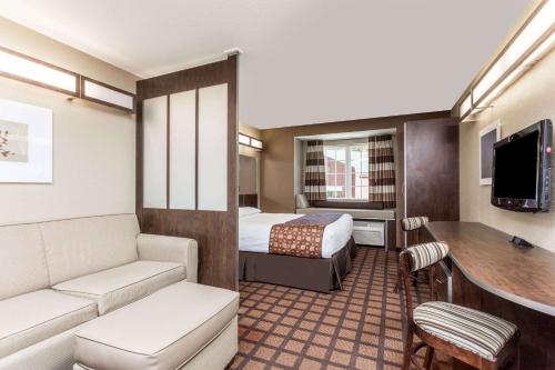 a small hotel room with a bed and a desk at Microtel Inn & Suites by Wyndham Macon in Macon