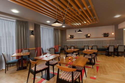 a restaurant with wooden tables and chairs in a room at Ramada Encore Newcastle-Gateshead in Newcastle upon Tyne