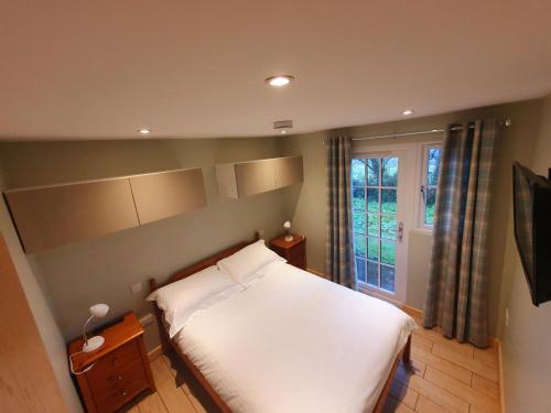 sypialnia z białym łóżkiem i oknem w obiekcie 41 Tudor Court w mieście Hayle