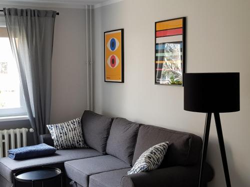 a living room with a gray couch and a window at Apartament Monika in Kłodzko