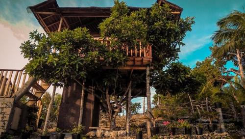 a tree house with a balcony on top of it at Kamp Aninipot in Siquijor