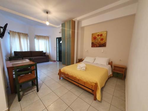 a bedroom with a bed and a desk and a couch at Countryside Studios in Ayia Evfimia