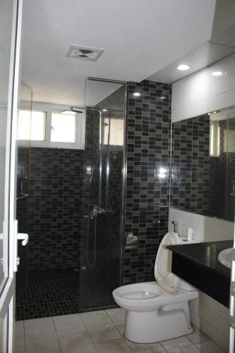 a bathroom with a shower and a toilet and a sink at An Phú Motel in Hanoi