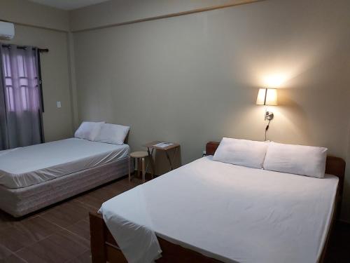a hotel room with two beds and a window at Waterland Suites in Paramaribo