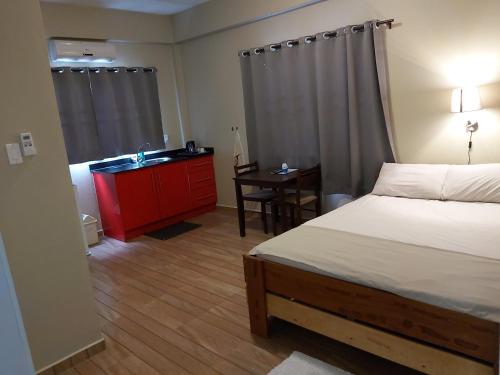 a bedroom with a bed and a desk and a sink at Waterland Suites in Paramaribo