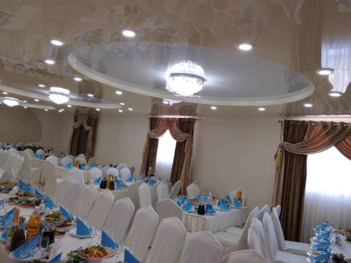 a banquet hall with white tables and white chairs at Racu in Komrat