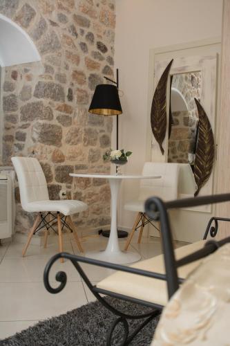 a room with a table and chairs and a stone wall at Paradiso in Hydra