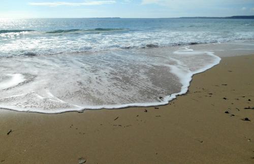 a sandy beach with the ocean and waves at Polytropon Apartments in Kástron