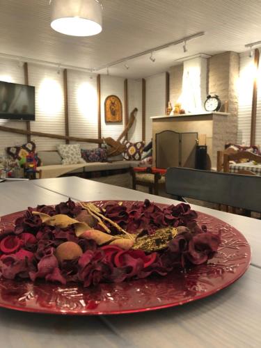 eine rote Platte mit Rosen auf einem Tisch in der Unterkunft Acrotel Sofia's Guest House in Sidherás