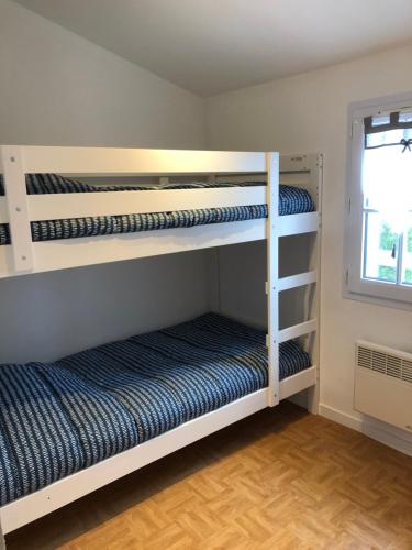 two bunk beds in a room with a window at Maison Bord de Mer LE BIGORNEAU l'Herbaudière in Noirmoutier-en-l'lle