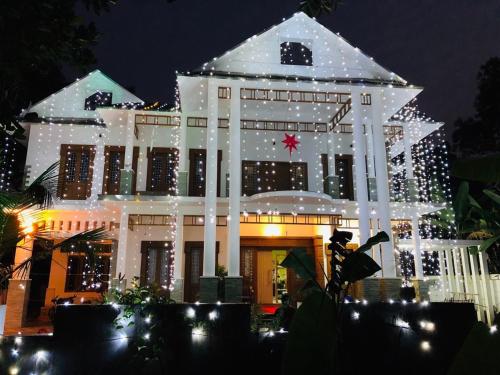 a building decorated with christmas lights at night at Thottungal Homestay in Ernakulam