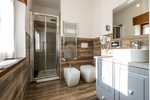 a bathroom with a shower and a toilet and a sink at Locanda Zita in Sestola