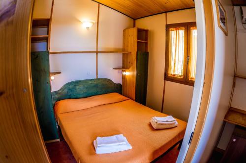 Habitación pequeña con 1 cama con 2 toallas. en Agriturismo Valle di Marco, en Palinuro