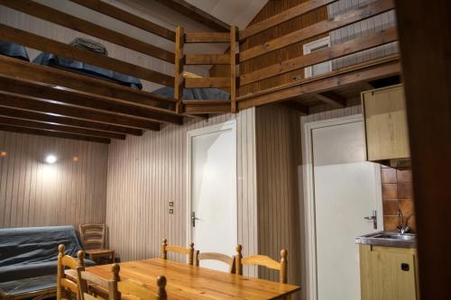 a dining room with a table and a bunk bed at La Bastide d'Albignac in Le Dourn