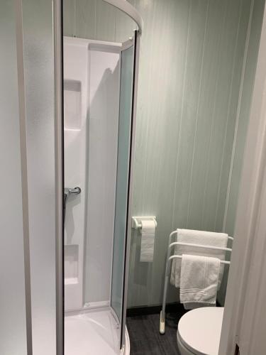 a bathroom with a shower with a toilet and a chair at Le Melchior in Sainte-Terre