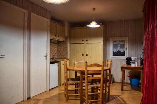 a kitchen with a table and chairs in a room at La Bastide d'Albignac in Le Dourn
