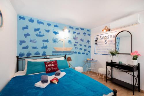 a blue bedroom with a bed and a desk at 4 Seasons Suites Paradise Athens Airport in Markopoulo