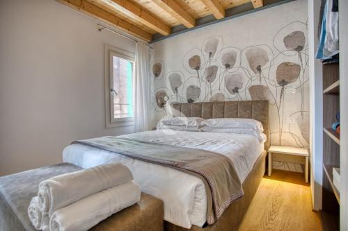 1 dormitorio con 1 cama y una pared con un mural en Ca' dei Battuti Apartments en Treviso