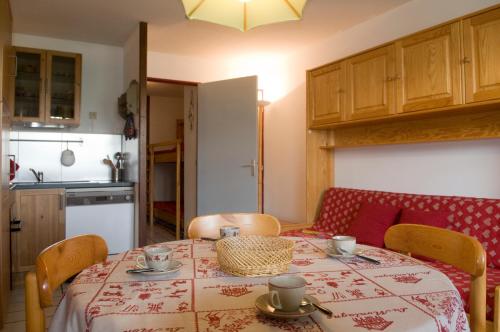 eine Küche mit einem Tisch und Stühlen sowie einem Tisch und einem Tisch in der Unterkunft Granges 8 - BEL APPT 4P AU PIED DES PISTES DOMAINE ALPE D'HUEZ in Villard-Reculas