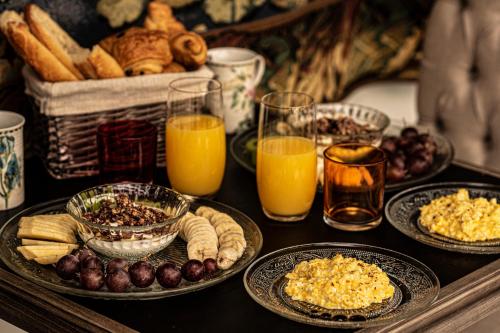 ラ・ボールにあるAmirautéの食べ物の皿とオレンジジュースのグラスが置かれたテーブル