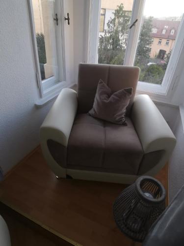 a couch sitting in a room with two windows at Pension und Ferienwohnung Stadt Altenburg in Altenburg