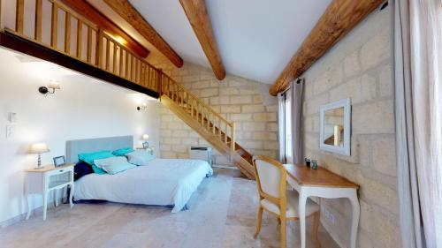 een slaapkamer met een bed, een bureau en een trap bij Le Mas de Guiguite in Mézoargues